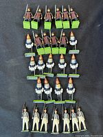 All 24 metal toy soldiers arranged in rows to show uniform variations and paint wear