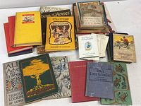 Assorted hardcover books spread on white surface showing variety of titles