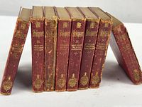 Partial set of seven Shakespeare Handy Volume Editions with worn red covers and gilt titles on spines.