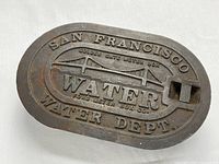 Top view of the cast iron utility cover showing the embossed Golden Gate Bridge design, 'San Francisco Water Dept.' and 'Golden Gate Meter Box' text.