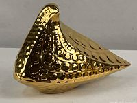 Front-left angle view showing reflective gold surface and decorative textured patterns on the ceramic partridge figure.