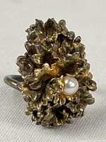 Close-up photo of the flower-shaped gold dipped ring with a pearl centerpiece.