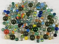 Glass marbles of various sizes and colors spread out showing diverse designs and patterns.