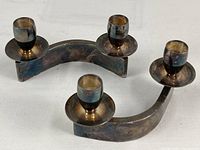 Photo shows the pair of modern silverplate candle holders with curved bases and two candle cups each, illustrating their size and tarnished patina.