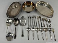 Silverplate serving ware grouping, includes oval floral platter, round bowl, forks, knives, spoons, and collectible spoons.