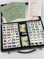 Complete open Mah Jongg set displayed in case with tiles, racks, dice, rule books, and point counting card visible.