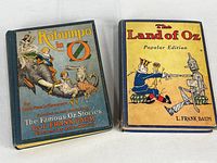 Two vintage books 'Kabumpo in Oz' and 'The Land of Oz' shown side by side with cover art visible.