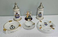 Group shot of all items: two steins, two ashtrays, teacup, saucer, Lancaster globe
