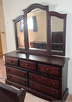 Front view of dresser with attached tri-panel mirror showing overall design