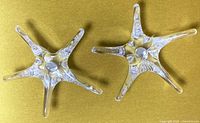 Two Daum France star-shaped crystal candle holders top view