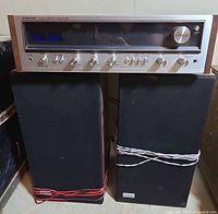 Front view of Pioneer SX-535 receiver atop two black bookshelf speakers with speaker wires