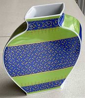 Front view of porcelain vase showing chartreuse and royal blue bands with gold motifs