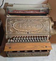 Full view of National brass cash register with wooden drawer front