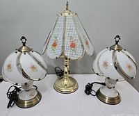 Front view of three vintage glass shade lamps