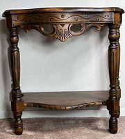 Front view of carved wooden side table showing apron and legs