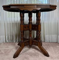 Full view of table showing pedestal base and carved details