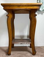 Front view of wooden occasional table showing overall design and curved legs
