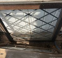 Front view of one leaded glass window showing diamond lattice and wood frame