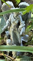 front view of angel with child statue among foliage