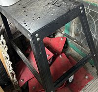 Overall view of black steel work surface showing top panel with drilled holes and leg structure