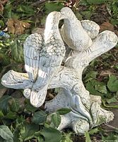 Full view of concrete dove statue showing birds and branch