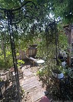 Full view of black metal arbor with vines and rust