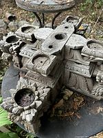 Top view of weathered carved wooden piece showing cross shape, circular recesses, floral carvings
