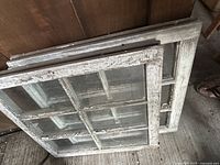 Both six-pane window sashes stacked showing overall size, paint wear and glass condition