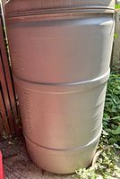 Full view of gray plastic rain barrel showing exterior
