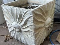 Square concrete planter with raised radial flower motif