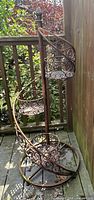 Full view of spiral wrought iron stand showing three tiers and scrollwork