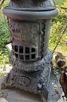 Full view of Walker Brilliant cast iron parlor stove showing ornate design and brand name on door
