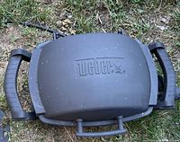 Closed Weber portable grill top view showing brand logo and handles