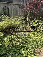 Full side view of wrought iron cart plant stand showing wheels, tray, handle