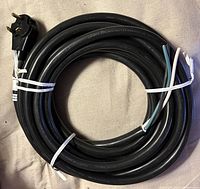 Coiled 30-ft black RV power cord showing male plug and stripped leads