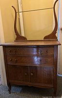 front view of antique wood dresser with attached mirror supports