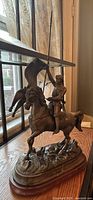 Full view of bronze equestrian statue on wood surface