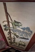 Full view of framed needlepoint showing landscape scene