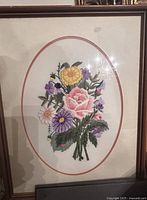 Frontal view of embroidered floral artwork in frame