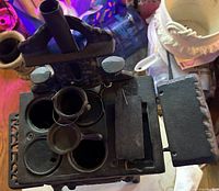 Full view of miniature cast iron stove with accessories on top