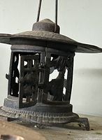 Close view of cast iron lantern showing pierced panel and roof