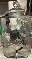Front view of square hammered-glass dispenser with lid and spigot