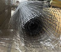 End view of partially unrolled galvanized mesh roll showing square grid