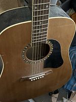 Front view of Ashbury acoustic guitar showing soundboard, rosette, bridge, strings