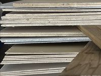 Stack of multiple thin birch plywood sheets showing veneer layers