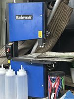 Front view of blue Mastercraft bandsaw showing table and blade