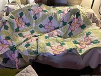 Quilt draped to show overall floral appliqué pattern and scalloped edge