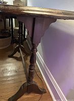 Side view of wood console table showing turned legs, apron and stretcher