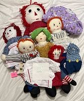 Group shot of six rag dolls with extra clothes on white background