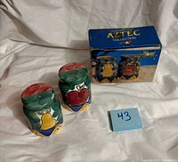 Front view of both ceramic shakers and box